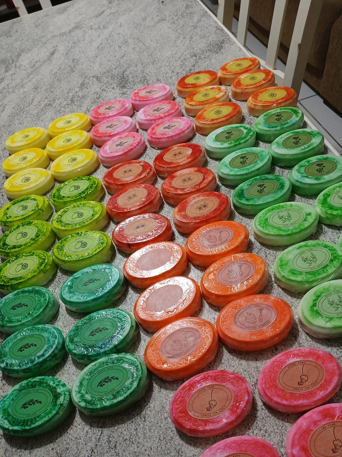 Dezenas de sabonetes artesanais coloridos enfileirados sobre a bancada