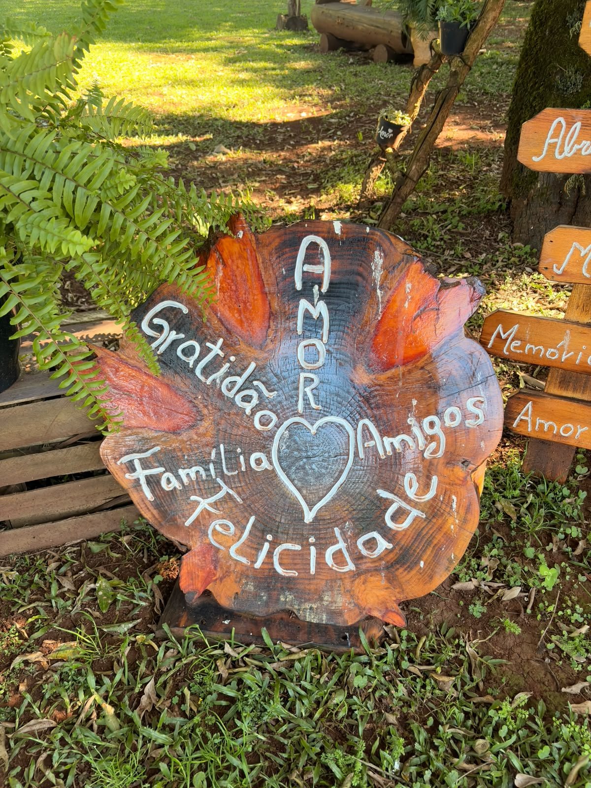 Fatia de tronco pintada com as palavras amor, gratidão, família, amigos e felicidade
