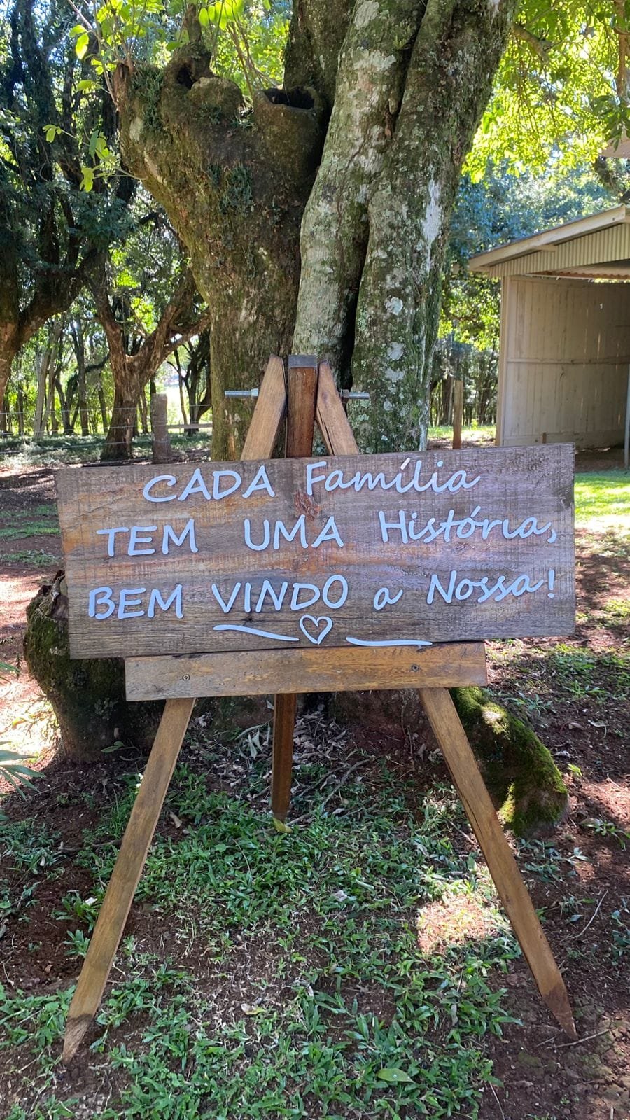 Placa de madeira num cavalete: cada família tem uma história, bem-vindo à nossa